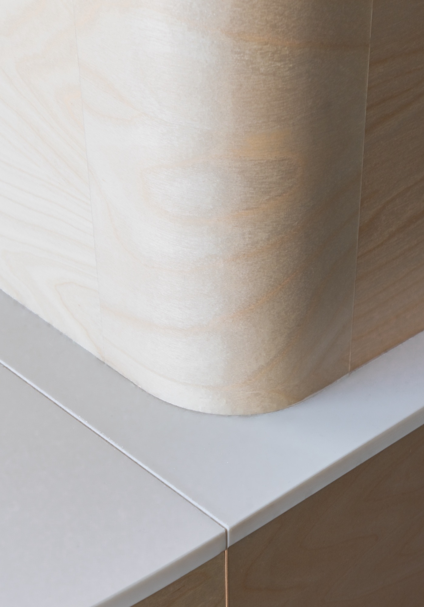 Bent plywood meeting a stone surface